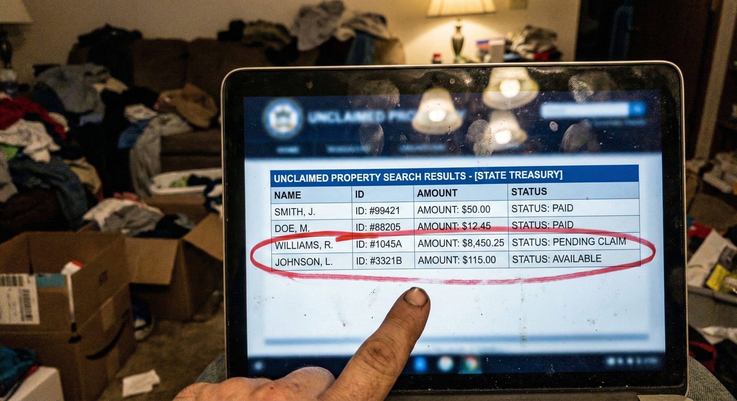 Laptop screen showing "Claim Found" on a state treasury website with the dollar