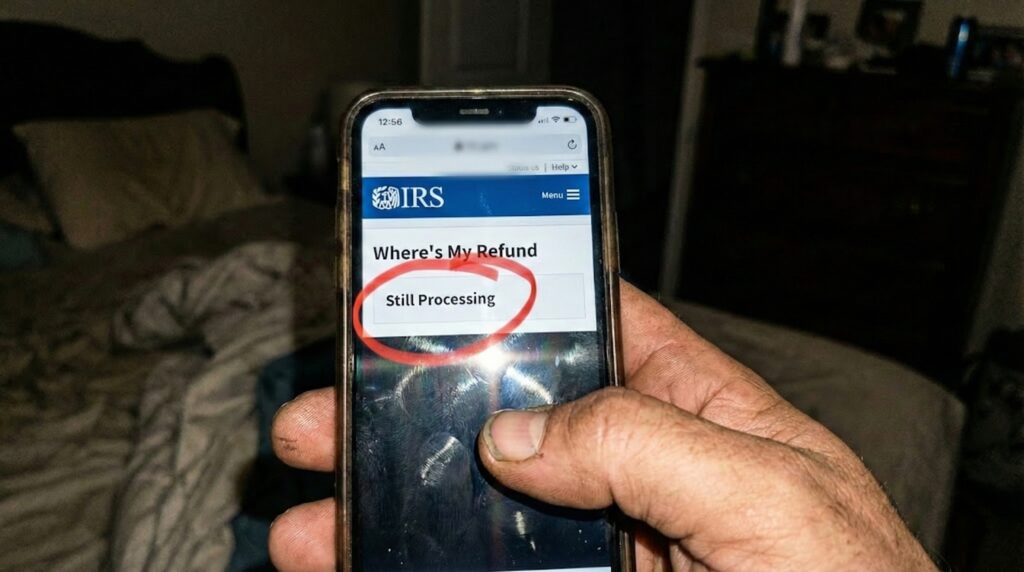 Phone screen showing WMR "Still Processing" status circled in red marker.